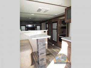 The Keystone 32RDDS Travel Trailer features a spacious kitchen, huge dinette counter, and rear entertainment lounge.