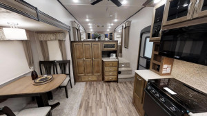 The Coachmen Chaparral 370FL has a huge kitchen area and three space living separating the living room, kitchen, and bedroom.